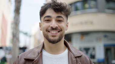 Young arab man smiling confident standing at street