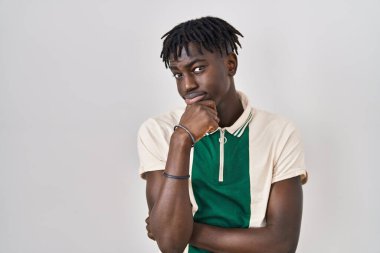 Afrika kökenli Afrikalı bir adam izole edilmiş arka planda durup bir soru hakkında endişeli ve gergin bir şekilde düşünüyor. 