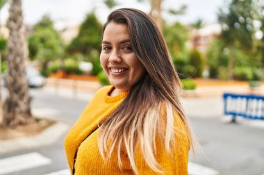 Young beautiful plus size woman smiling confident standing at street