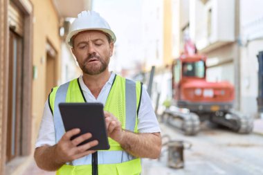 Middle age man architect using touchpad at street