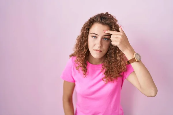 Young Caucasian Woman Standing Pink Background Pointing Unhappy Pimple Forehead — Zdjęcie stockowe