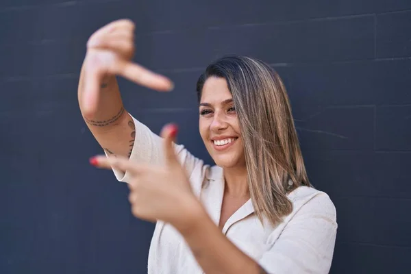 Молодая Латиноамериканка Улыбается Уверенно Делая Фото Жест Руками Стоящими Стены — стоковое фото