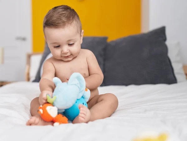 可爱的高加索婴儿在卧室的床上玩大象玩具 — 图库照片