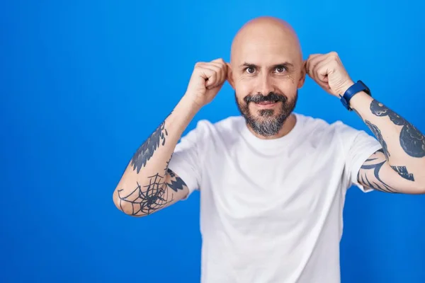 Hombre Hispano Con Tatuajes Pie Sobre Fondo Azul Sonriendo Tirando —  Fotos de Stock