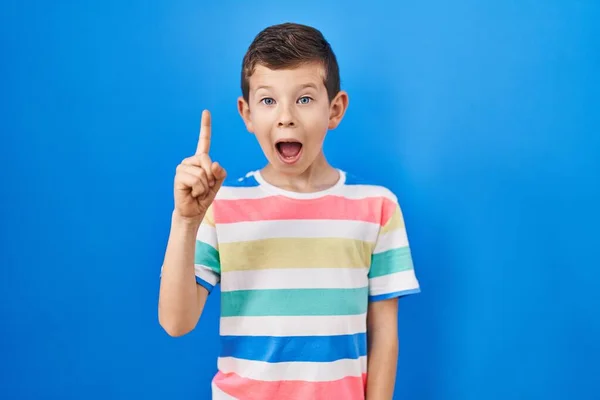 Niño Caucásico Joven Pie Sobre Fondo Azul Señalando Con Dedo —  Fotos de Stock