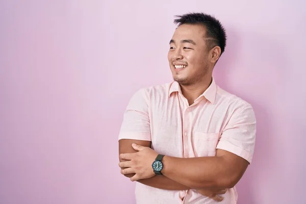 Китайський Молодий Чоловік Стоїть Над Рожевим Фоном Дивиться Убік Посмішкою — стокове фото