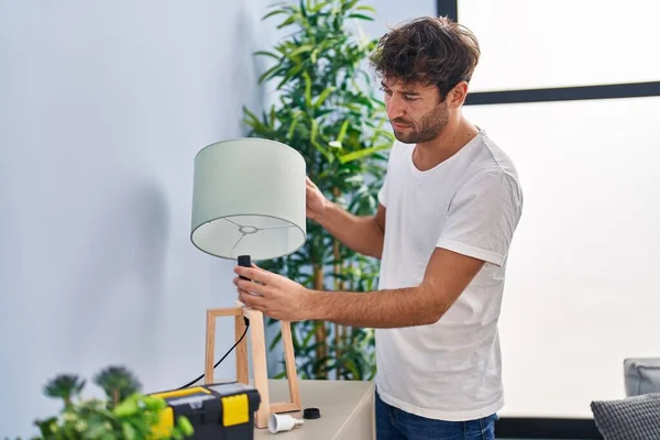 Młody Człowiek Naprawia Lampę Domu — Zdjęcie stockowe