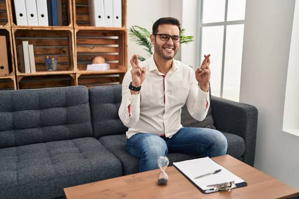 Young Hispanic Man Beard Working Consultation Office Gesturing Finger Crossed — Stock Photo, Image