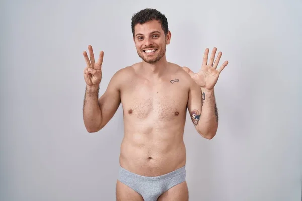 Ung Latinamerikansk Man Står Tröjlös Klädd Underkläder Visar Och Pekar — Stockfoto