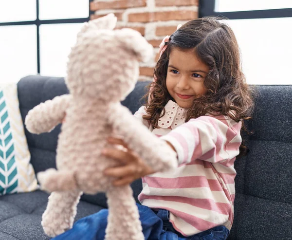 可爱的惊恐女孩抱着泰迪熊坐在家里的沙发上 — 图库照片