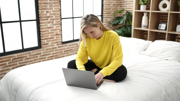 Молода Блондинка Використовує Ноутбук Сидячи Ліжку Спальні — стокове фото