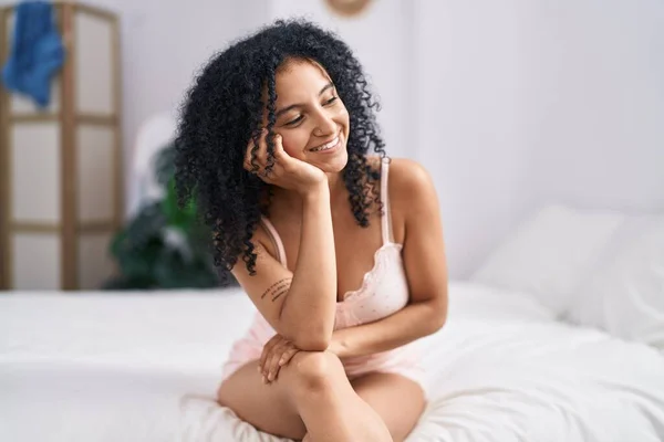 stock image Young hispanic woman smiling confident sitting on bed at bedroom