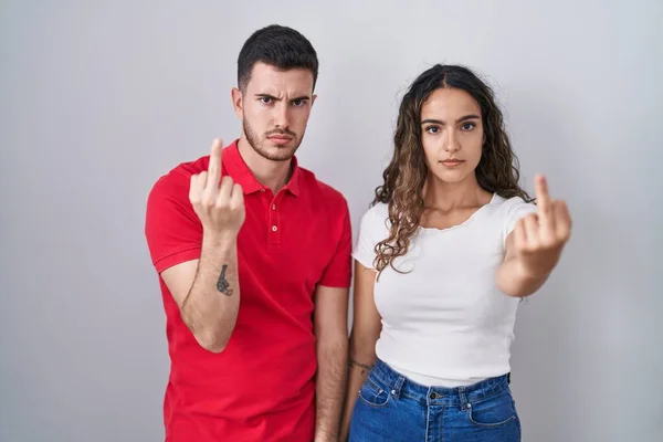 Young Hispanic Couple Standing Isolated Background Showing Middle Finger Impolite — Foto de Stock
