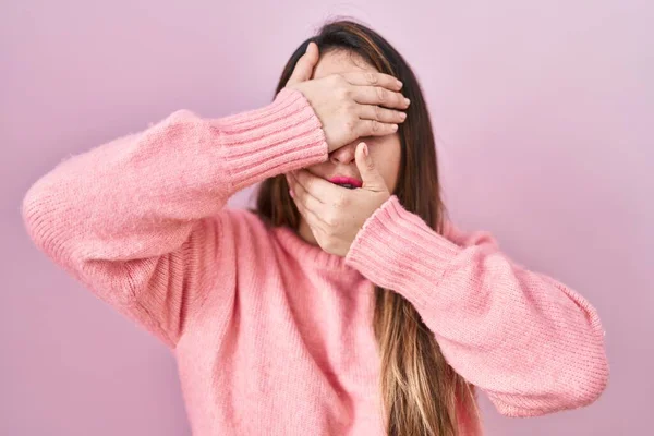 Young Hispanic Woman Standing Pink Background Covering Eyes Mouth Hands —  Fotos de Stock