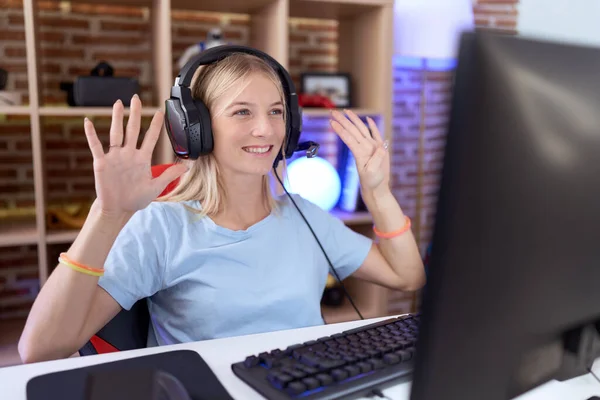 Молодая Белая Женщина Играет Видеоигры Наушниках Показывая Пальцами Номер Девять — стоковое фото