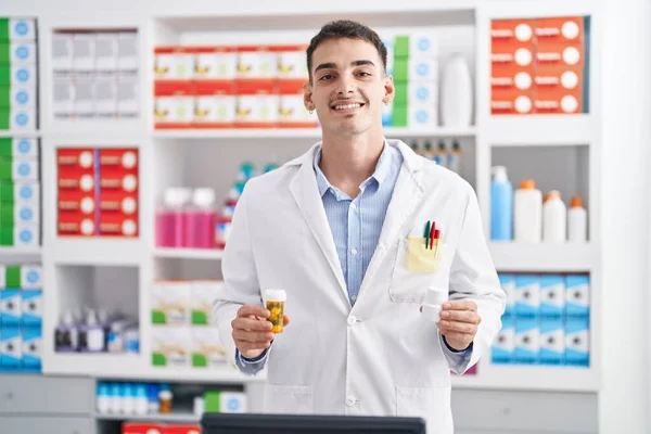 Young Hispanic Man Pharmacist Holding Pills Bottles Pharmacy — Fotografia de Stock