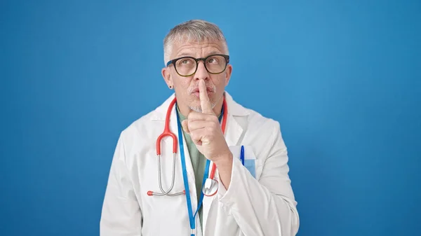 Grauhaariger Arzt Mittleren Alters Bittet Schweigen Über Isolierten Blauen Hintergrund — Stockfoto