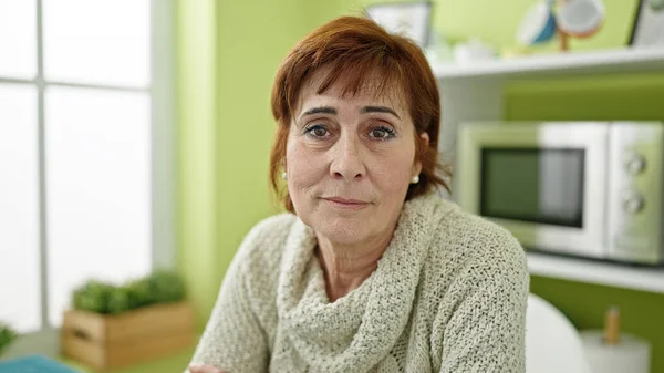 Reife Hispanische Frau Sitzt Mit Ernstem Gesichtsausdruck Esszimmer — Stockfoto