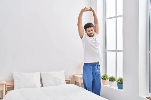 Young Arab Man Waking Stretching Arms Bedroom — стоковое фото