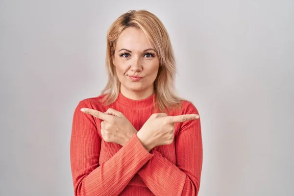Blondýny Žena Stojící Nad Izolovaným Pozadím Ukazuje Obě Strany Prsty — Stock fotografie