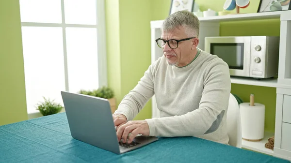 Evdeki Masada Oturan Orta Yaşlı Kır Saçlı Dizüstü Bilgisayar Kullanan — Stok fotoğraf