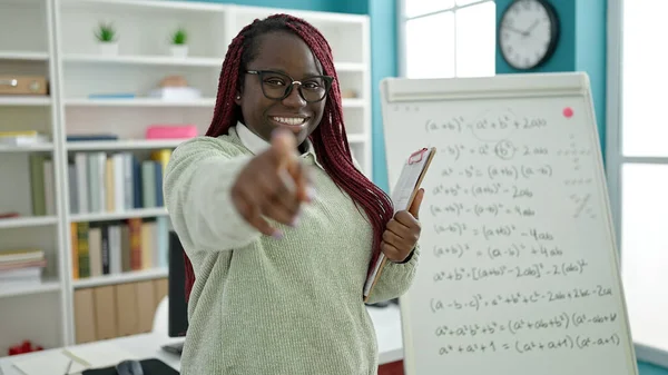 大学図書館でカメラを指す編組の髪の指導数学を持つアフリカの女性 — ストック写真