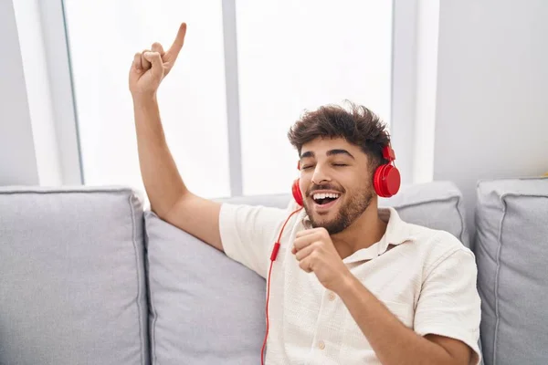 Genç Arap Adam Evdeki Kanepede Oturup Şarkı Söylüyor Müzik Dinliyor — Stok fotoğraf