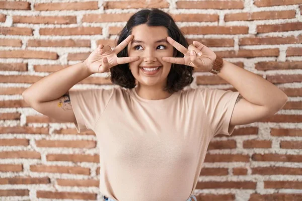 Young Hispanic Woman Standing Bricks Wall Doing Peace Symbol Fingers — Fotografia de Stock