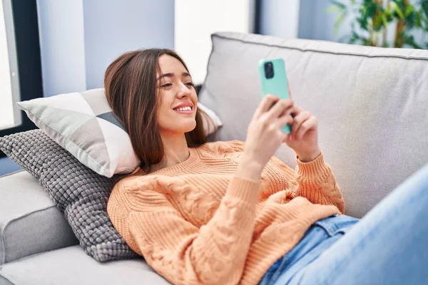 Junge Schöne Hispanische Frau Mit Smartphone Hause Auf Sofa Liegend — Stockfoto