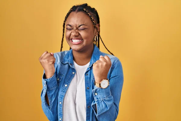 Afroamerikanerin Mit Zöpfen Vor Gelbem Hintergrund Aufgeregt Für Den Erfolg — Stockfoto