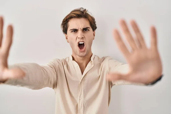 Młody Człowiek Stojący Nad Odosobnionym Tłem Zatrzymuje Gest Dłońmi Gniewną — Zdjęcie stockowe