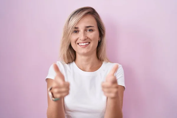 Young Blonde Woman Standing Pink Background Pointing Fingers Camera Happy — Stock Photo, Image
