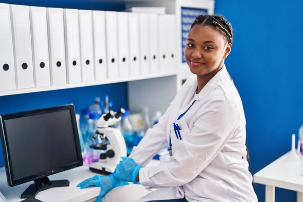 非洲裔美国女科学家在实验室使用显微镜 — 图库照片