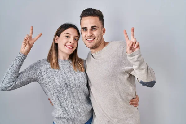Young Hispanic Couple Standing White Background Smiling Looking Camera Showing — Zdjęcie stockowe