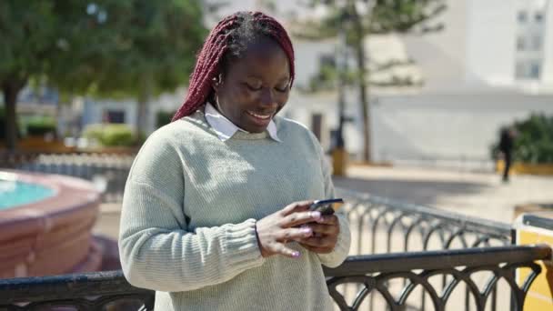 Parkta Akıllı Telefon Kullanan Örgülü Saçlı Afrikalı Bir Kadın — Stok video