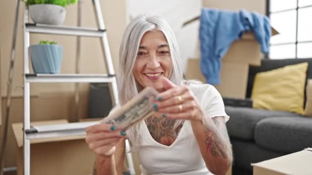 中年白发女子满脸笑容 自信地在新家持钱 — 图库视频影像