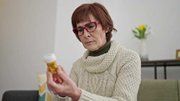 Reife Hispanische Frau Liest Tablettenetikett Auf Dem Sofa Hause — Stockvideo