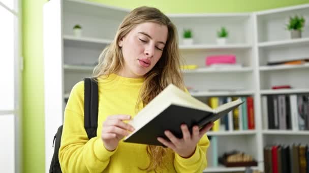 Jonge Blonde Vrouw Student Dragen Rugzak Lezen Notebook Bibliotheek Universiteit — Stockvideo