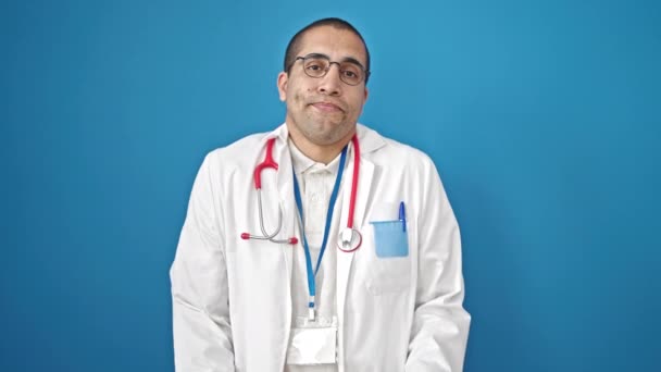 Молодой Латиноамериканец Доктор Стоящий Неведении Изолированном Синем Фоне — стоковое видео