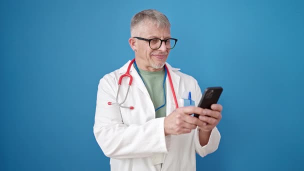 Μεσήλικας Γκριζομάλλης Γιατρός Χαμογελαστός Αυτοπεποίθηση Χρησιμοποιώντας Smartphone Πάνω Από Απομονωμένο — Αρχείο Βίντεο