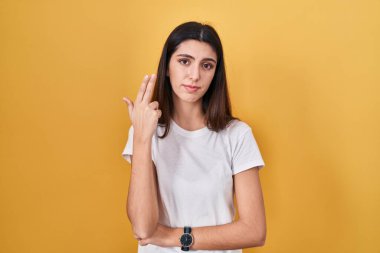 Genç ve güzel bir kadın sarı arka planda durup ateş ediyor ve kendini öldürüyor. Elini ve parmaklarını silah gibi kullanıyor. İntihar hareketi.. 