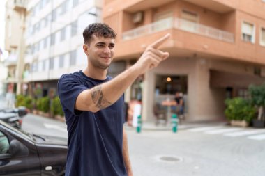 Genç İspanyol adam gülümsüyor. Kendine güveni tam. Sokakları işaret ediyor.