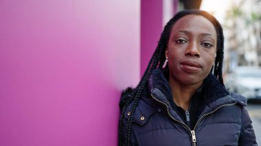 Sokakta ciddi bir ifadeyle duran Afrikalı Amerikalı kadın.