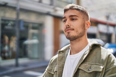 Sokakta kendinden emin gülümseyen İspanyol genç adam.