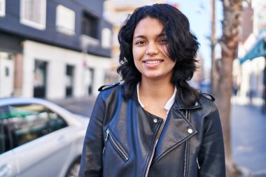 Sokakta kendine güvenen genç Latin kadın gülümsüyor
