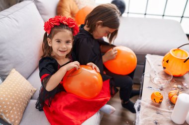 Sevimli kız ve erkek balonla cadılar bayramı partisi yapıyorlar.