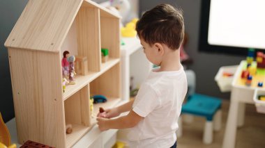 Anaokulunda oyuncak oynayan sevimli beyaz çocuk.