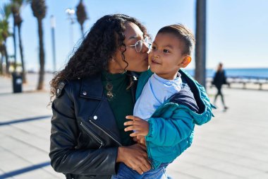 Mother and son hugging each other and kissing at seaside