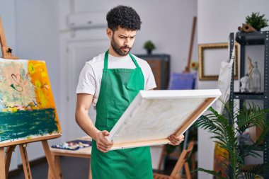 Sanat stüdyosundaki Arap adam şüpheci ve gergin, sorun yüzünden surat asıyor. negatif kişi. 