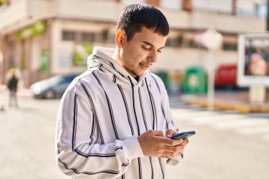 Sokakta akıllı telefon kullanan kendine güvenen genç adam.